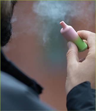 London, UK. 8 August 2023: A man vaping an e-cigarette in London. Local councils are calling for the Government to ban the sale and manufacture of single-use vapes by 2024. 