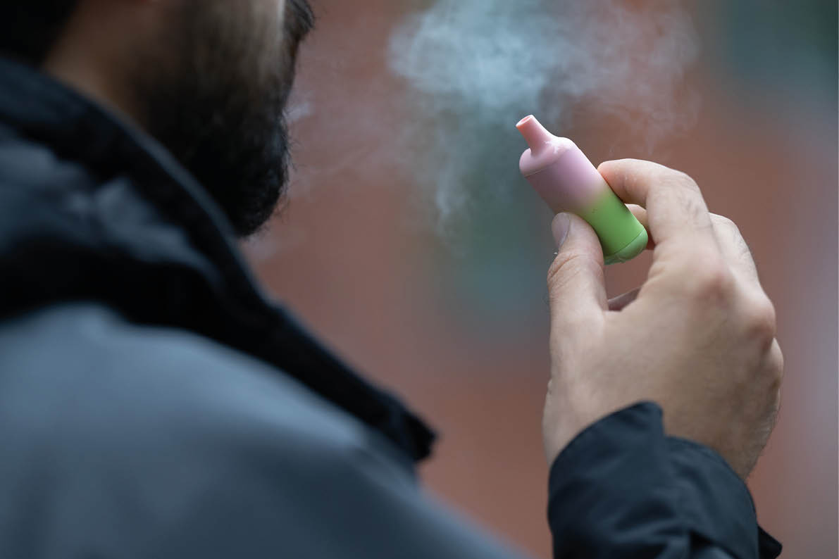 London, UK. 8 August 2023: A man vaping an e-cigarette in London. Local councils are calling for the Government to ban the sale and manufacture of single-use vapes by 2024. 