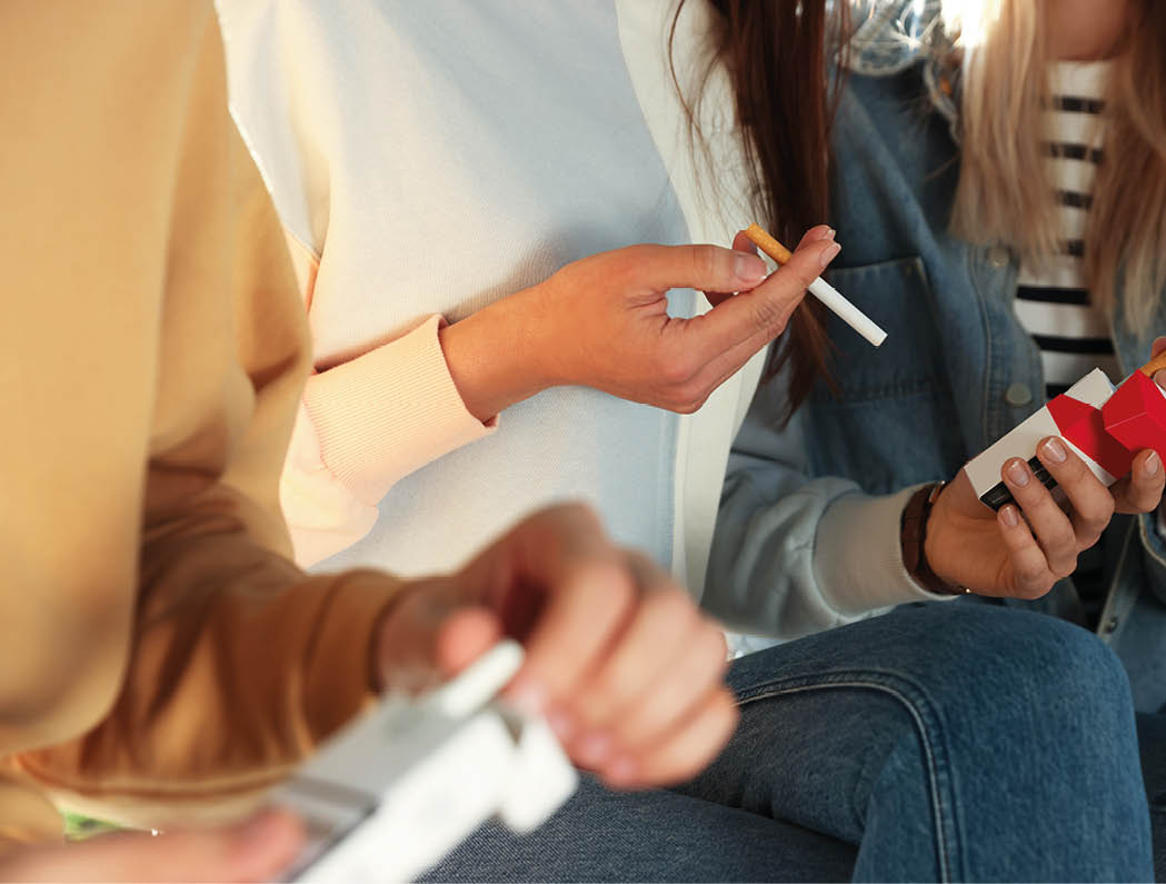 Man taking cigarette out of pack outdoors, closeup