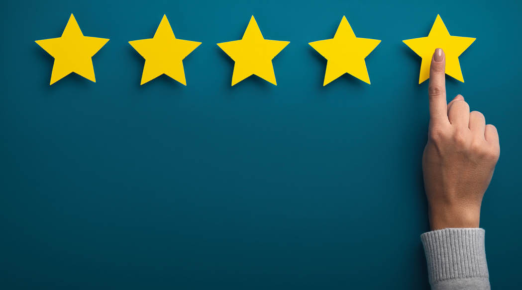 A hand is pressing a yellow star on a blue background. Description generated by AI