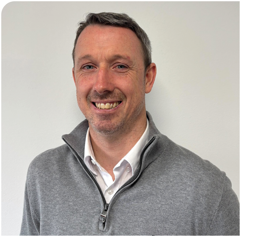 A man wearing a gray sweater and white shirt. Description generated by AI