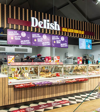 A deli counter with a variety of foods. Description generated by AI