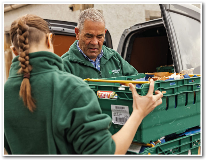 A man and a woman are loading crates into a truck. Description generated by AI