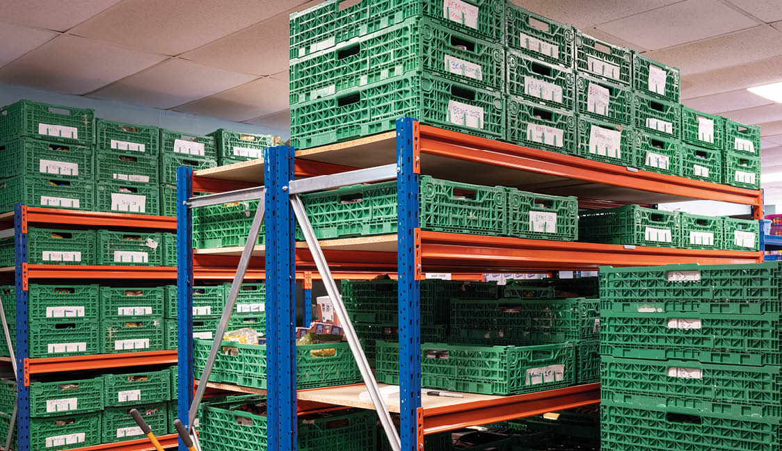 A storage room filled with green crates on shelves. Description generated by AI