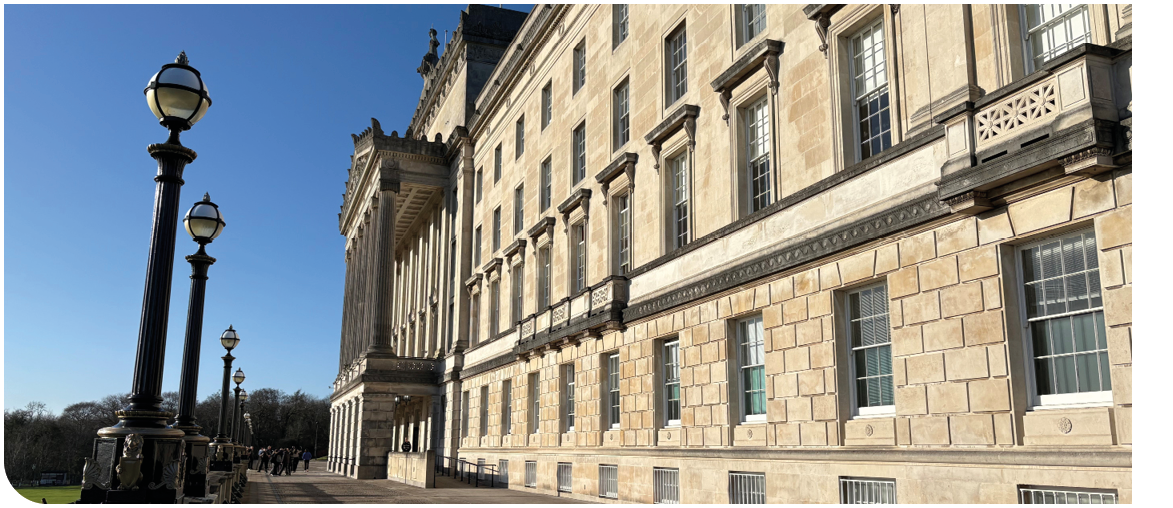 A large building with a clock tower and a stone facade. Description generated by AI