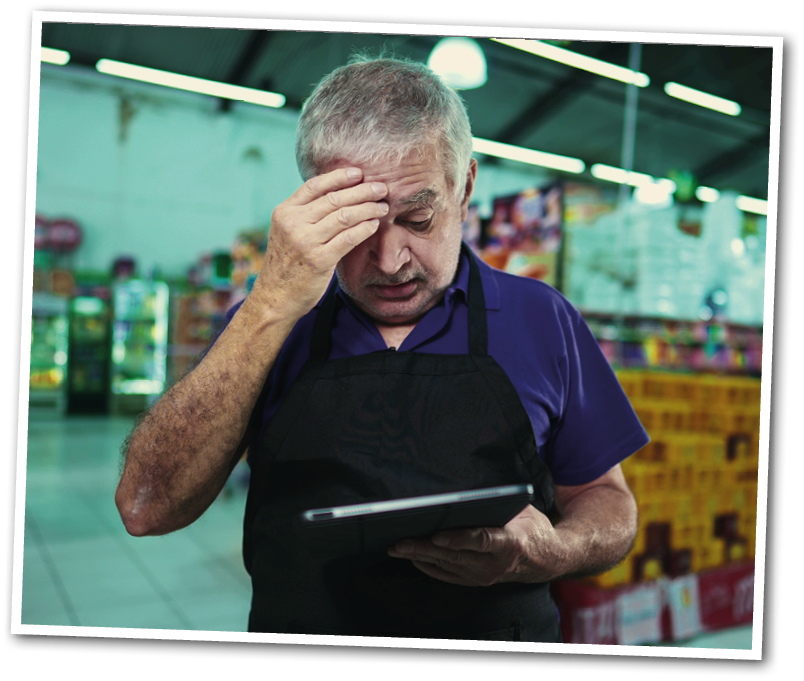 A man in a purple shirt is looking at a tablet. Description generated by AI