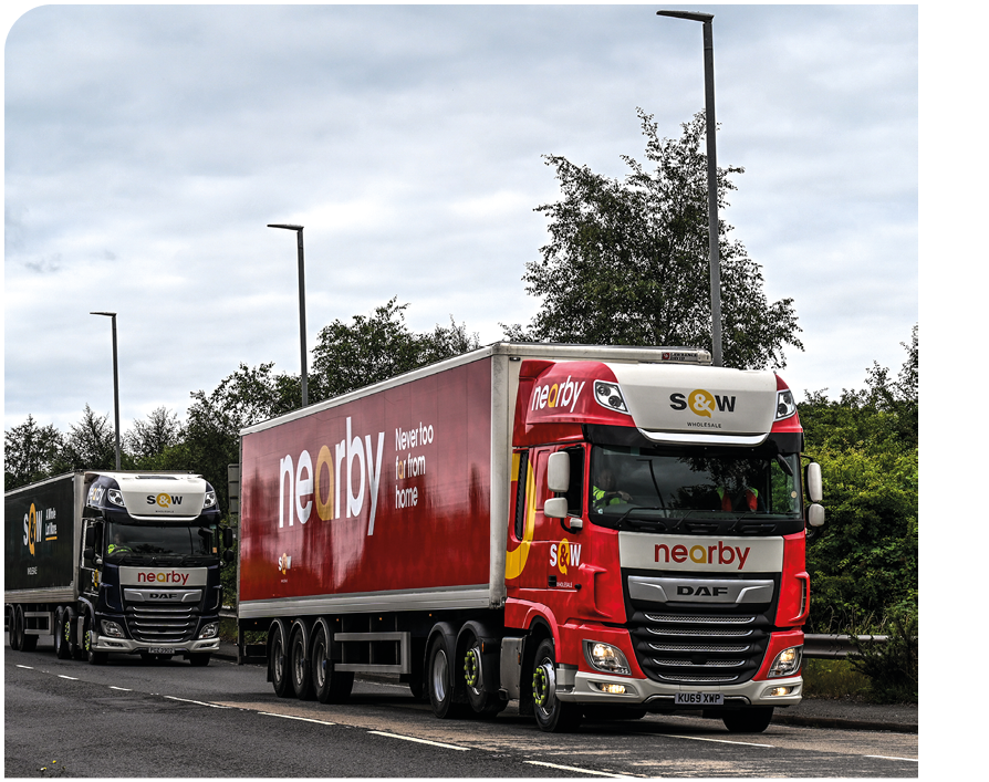 A red truck with the word “Neovia" on the side is driving down a road. Description generated by AI