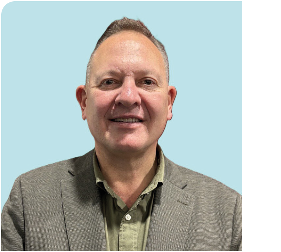 A man wearing a suit and tie smiling for a picture. Description generated by AI