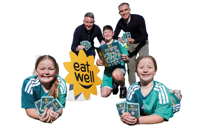 A group of children holding up a sign that says eat well. Description generated by AI