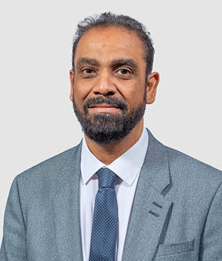 A man wearing a gray suit and tie. Description generated by AI