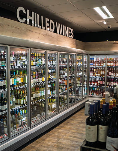 A store with a large display of wine bottles. Description generated by AI