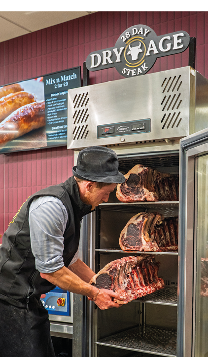 A man is reaching into a refrigerator to get meat. Description generated by AI