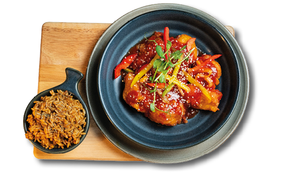 A plate of food with a bowl of rice and meat on a wooden table. Description generated by AI