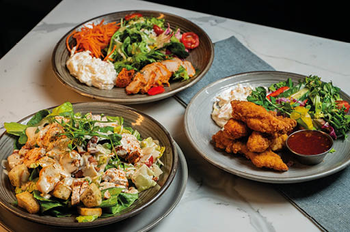 A table with three plates of food. Description generated by AI