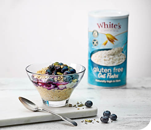 A bowl of cereal with blueberries and oats. Description generated by AI