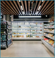 A grocery store with a tile floor and shelves of food. Description generated by AI