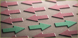 3D illustration of red arrows pointing the left side of the image and green ones in the opposite direction. Going against the grain concept