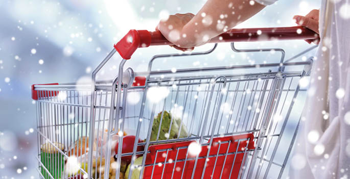 Young woman with shopping cart in store over snow effect