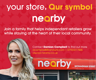 A person with long wavy hair wearing a black off-shoulder top stands next to a storefront with the sign “nearby" and text promoting a family of independent retailers. Description generated by AI