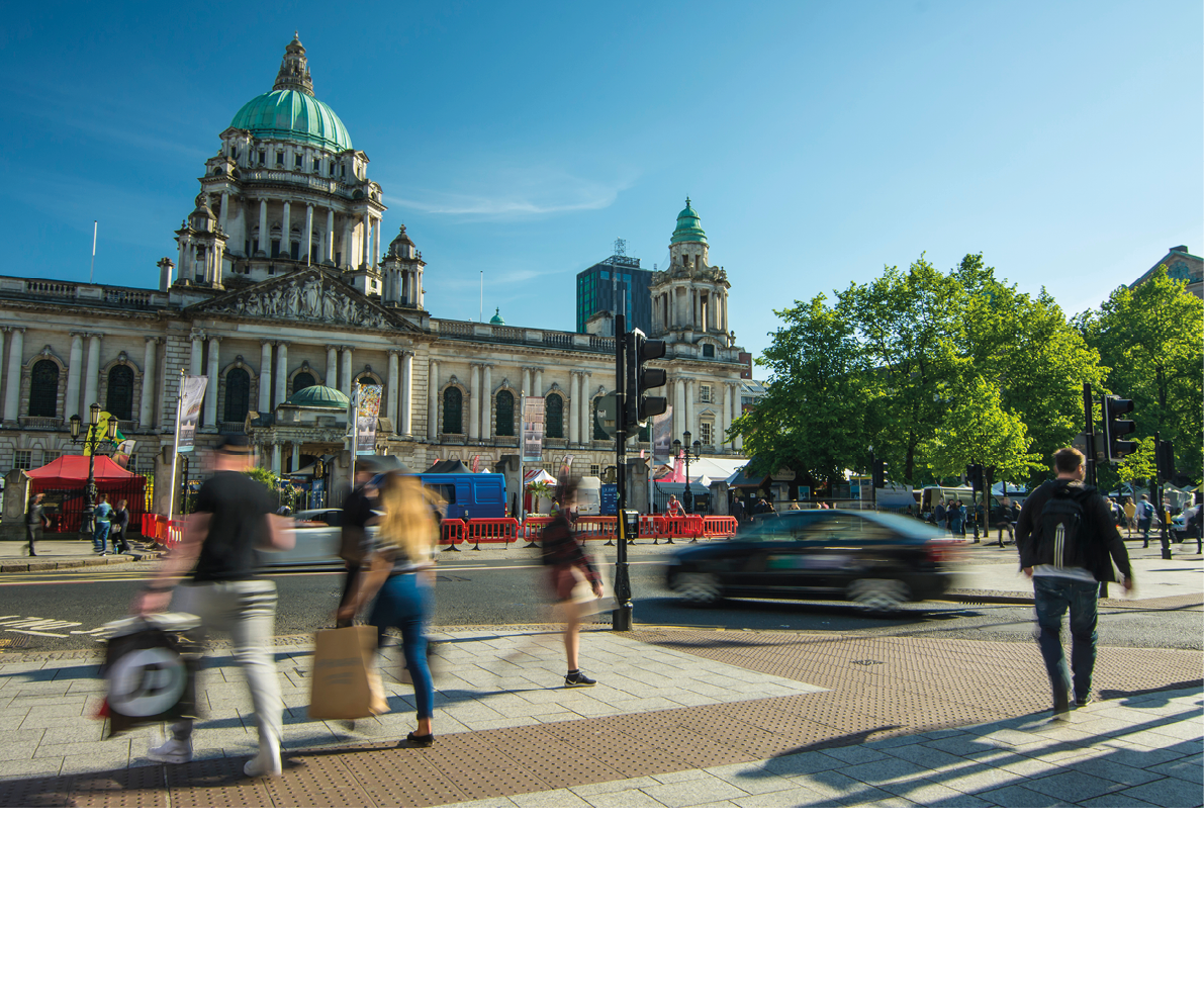 BELFAST, NORTHERN IRELAND- MAY, 2018: Motion blurred people in front of Belfast City Hall on Donegall Square