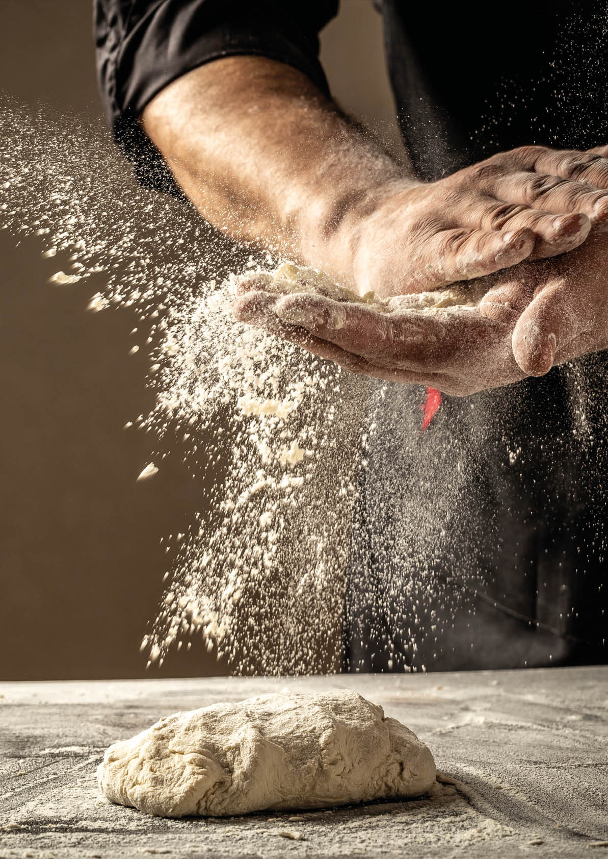 Photo of flour and men hands with flour splash. Cooking bread. Kneading the Dough. Isolated on dark background. Empty space for text.