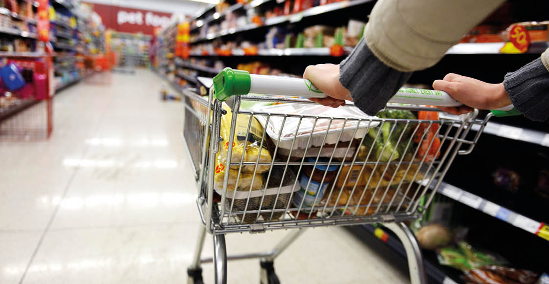 London, UK - August 18, 2014: A shopper pushes a trolley along an aisle in an Asda supermarket. American company Walmart owns Asda, which is UK's largest retail chain after Tesco with 568 stores.