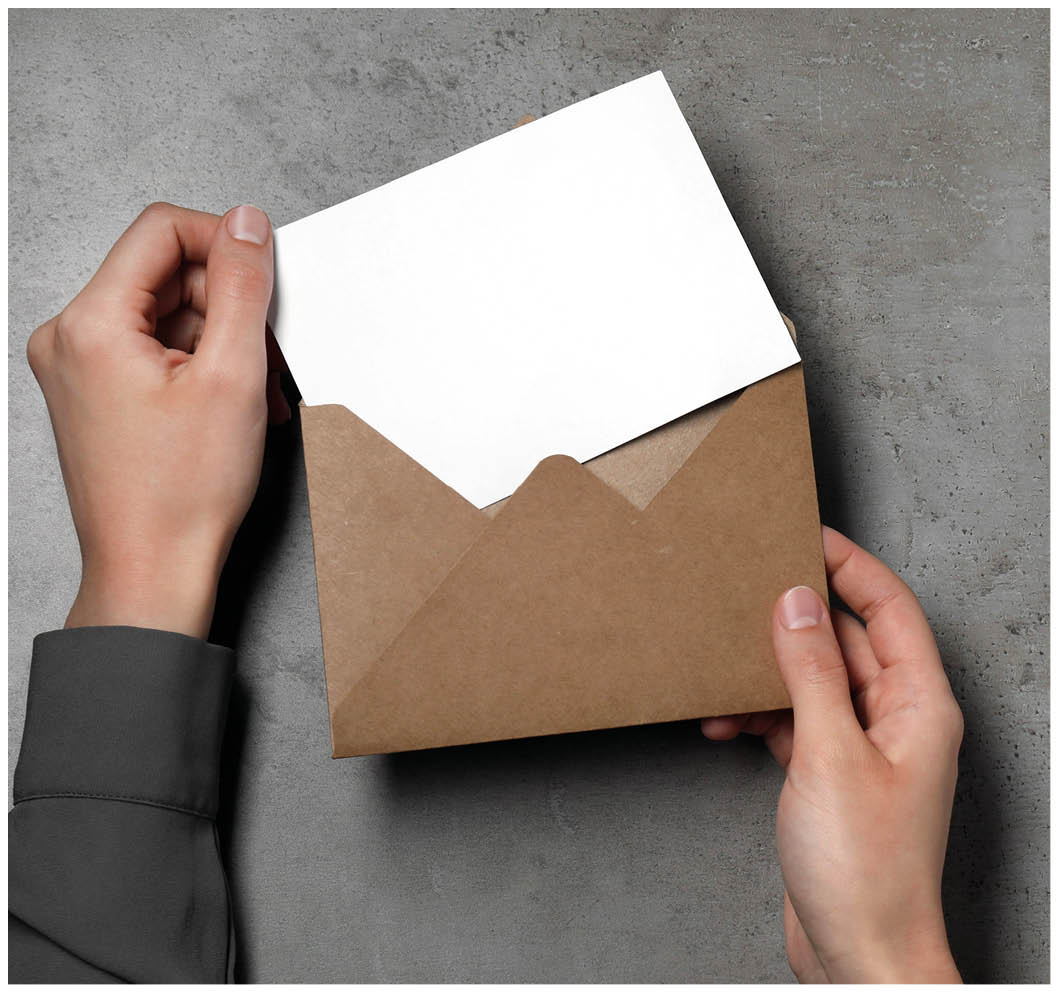 Woman taking card out of letter envelope at grey textured table, top view. Space for text