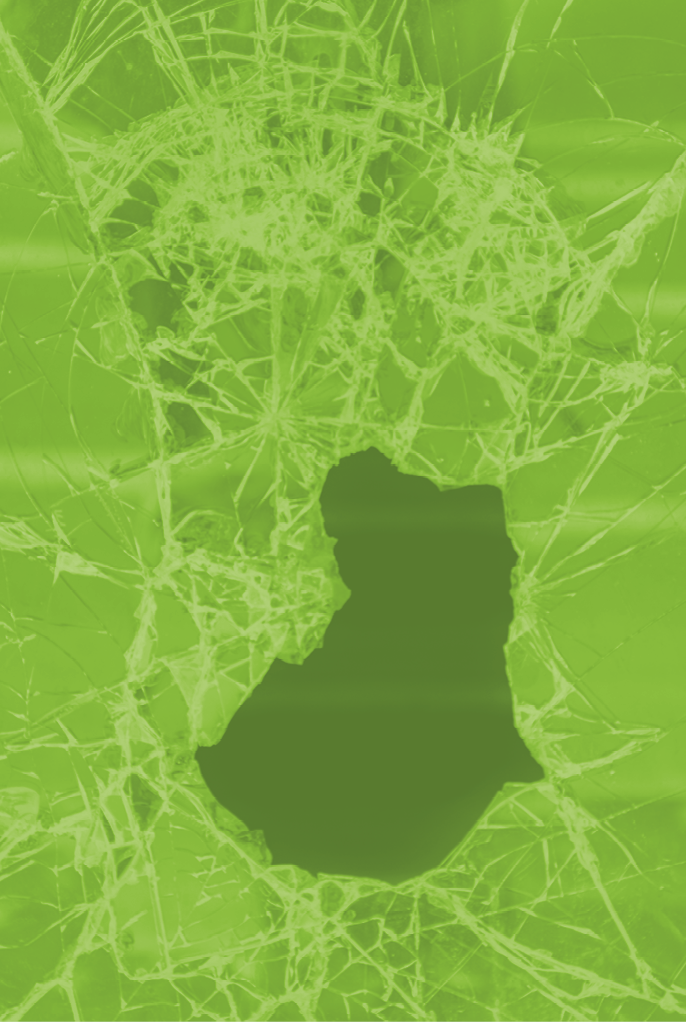 Hole in the broken glass of a shop window of a closed shop