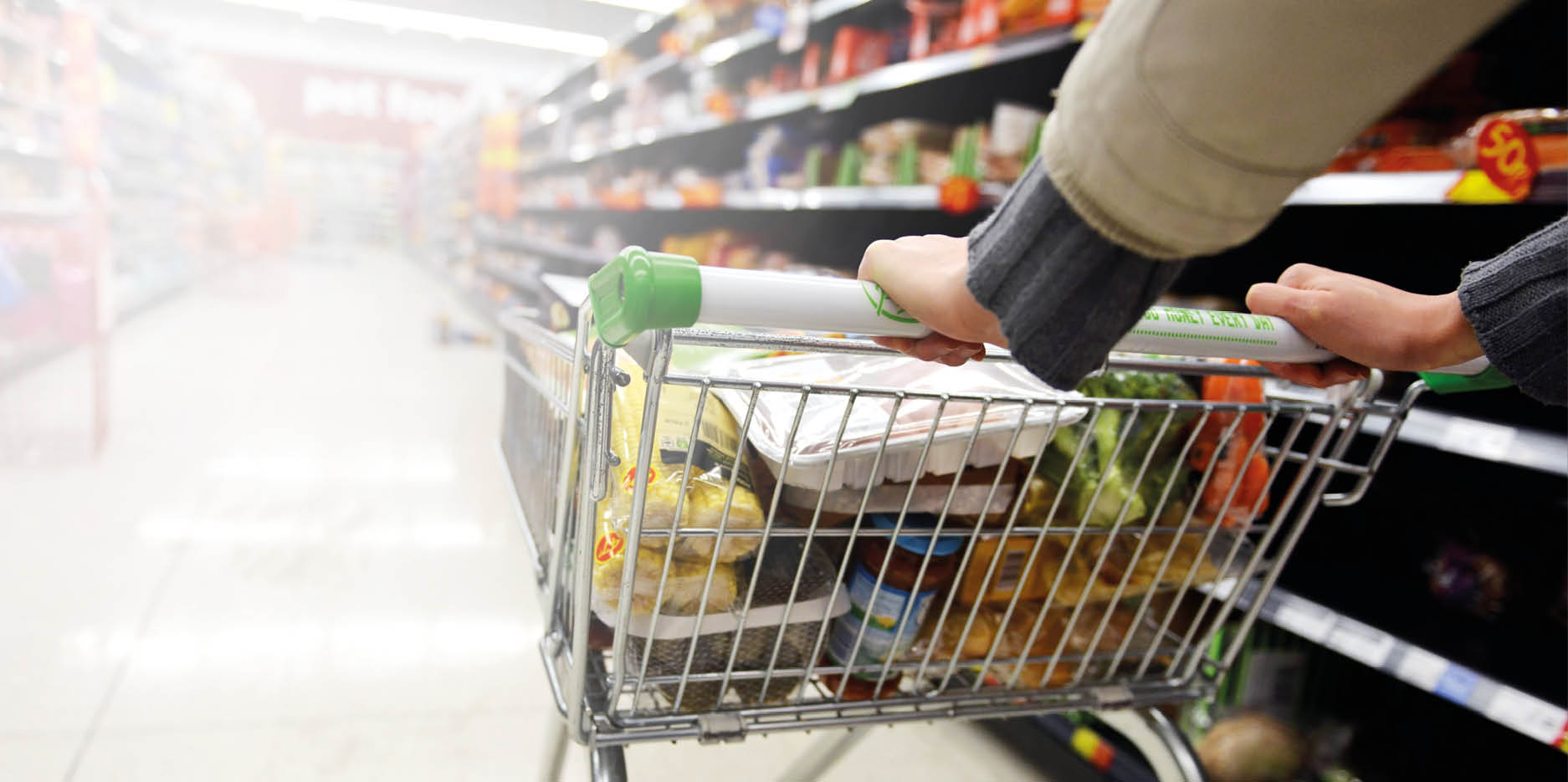 London, UK - August 18, 2014: A shopper pushes a trolley along an aisle in an Asda supermarket. American company Walmart owns Asda, which is UK's largest retail chain after Tesco with 568 stores.