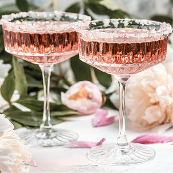 Rose wine in glass and peony flowers over white background, Summer celebration, wedding greeting card, invitation concept.