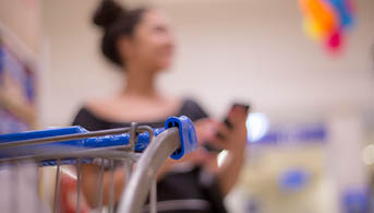 Sale, shopping, consumerism and people concept - happy young woman with smartphone choosing and buying food in market