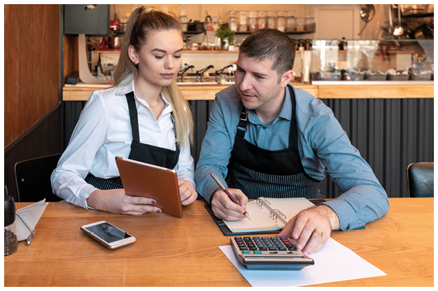 New small business owners counting revenue and expenses - Start-up entrepreneurs, woman and man, businessmen doing accounting with calculator and tablet in Restaurant