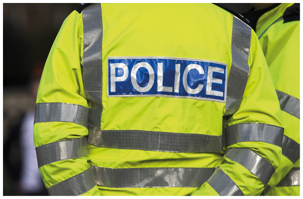 Shot of the back of a police officer's jacket with the word police written across the back