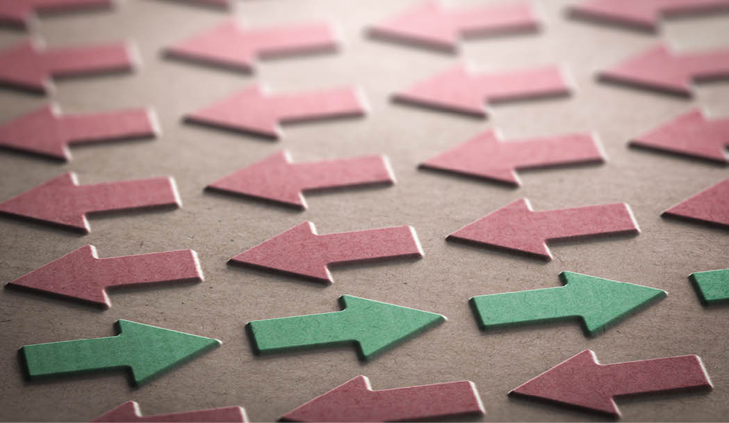 3D illustration of red arrows pointing the left side of the image and green ones in the opposite direction. Going against the grain concept