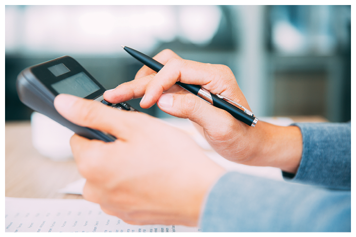Close-up of male hands with pen using calculator
