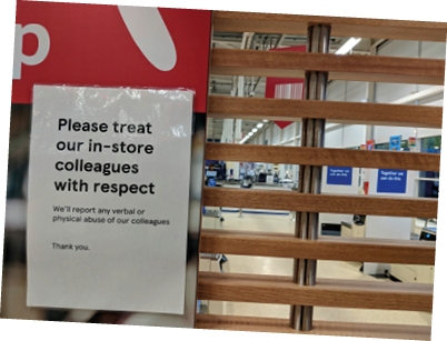 MANSFIELD, UK - MAY 9, 2020: White, selectively focused “Please treat colleagues with respect. We'll report verbal or physical abuse" sign on wooden railing at Sainsbury's during COVID-19 Pandemic