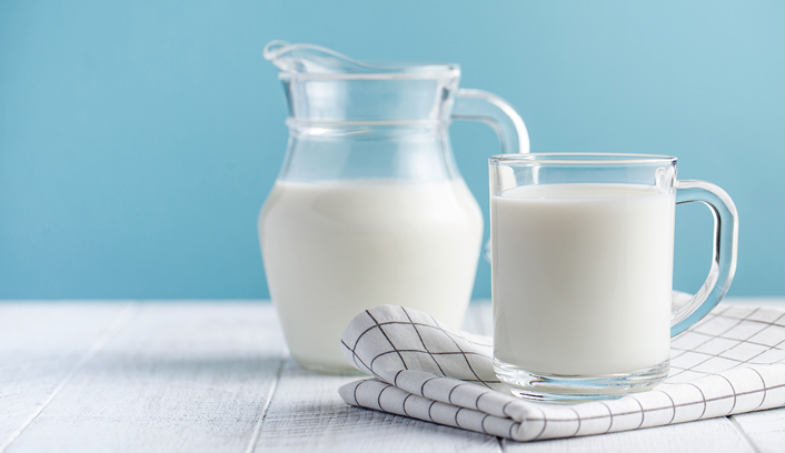 Banner of a glass of milk, a jug of milk on blue background. The concept of farm dairy products, milk day. Copy space.