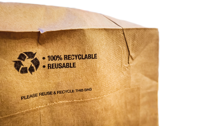 Brown paper bag that is 100% recyclable and reusable on a counter. A printed plea for user to recycle and reuse this bag as a form of packaging.