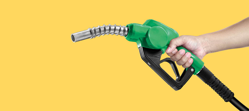 Hands holding Fuel nozzle on yellow background