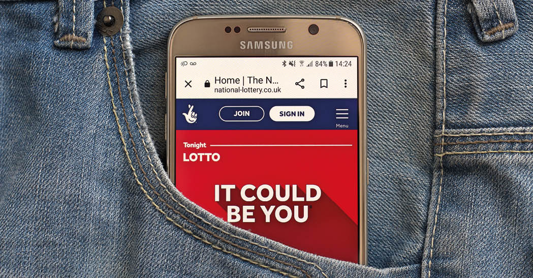 Warrington, cheshire UK - february 25 2023: National lottery UK, lotto game page on smartphone in jeans pocket.