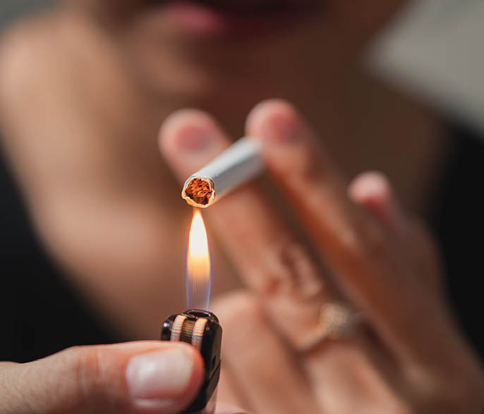 Smoker lighting a cigarette with lighter