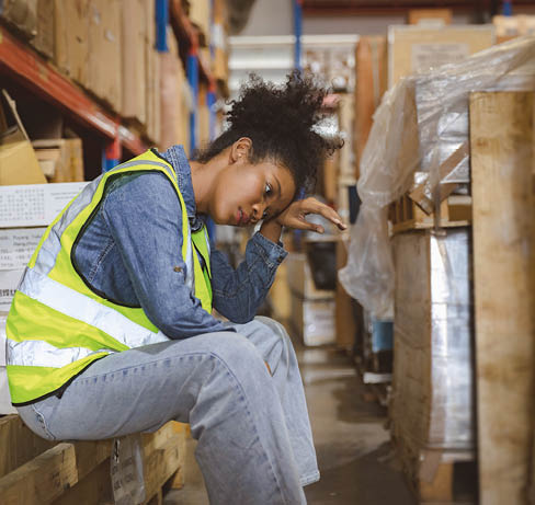 Tired stress woman worker labor working in warehouse cargo inventory industry.